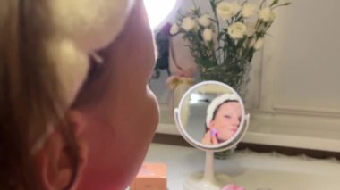 Kaplama, bronzlaştırıcı makyaj malzemesi. Güzel bir genç kadının portresi pürüzsüz bir cilt ve taze makyaj ve fırçayla yapılmış eller makyaj, dış hatlar ve kadın yüzü..