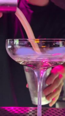 Pembe içecek, bir kokteyl bardağına konan bir kozmopolit olabilir. Yanında da bir portakal asılıydı. Yüksek kalite 4k görüntü