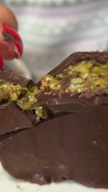 Dubai çikolata detayı. Dubai çikolatası, sıvı fıstık ezmesi ve kadaif. Beyaz arka planda yeşil kadaif ve fıstık ezmeli Dubai çikolatası. Halep Tatlıları.