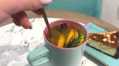 Karamelli ve fıstıklı escake. Turkuaz bardakla tabak kış çayı. Tarçınlı, limonlu ve biberiyeli. Yüksek kalite 4k görüntü