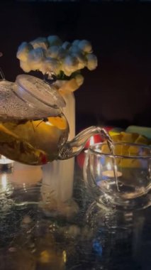 Akşam çay partisi akşam mumları yeşil çay bir cam fincana dökülür siyah çiçekler beyaz. Yüksek kalite 4k görüntü