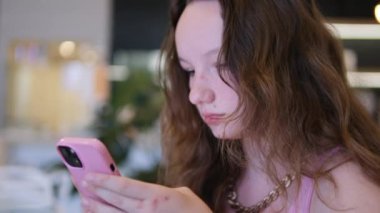 Akıllı telefon kullanan genç iş kadınının portresi. Şehirde cep telefonu kullanan güzel, siyah saçlı bir kadının yakın plan fotoğrafı. Yüksek kalite 4k görüntü