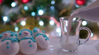 Güzel bir Noel kompozisyonu. Tabakta zencefilli kurabiye çeşitleri. Bir bardak süt, vanilya çubuğu, anason, çam, ceviz. Üst Manzara. Mavi arka planda. Yüksek kalite 4k görüntü