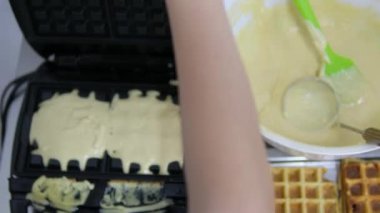 Waffle hamurunu sıcak bir waffle ızgarasına dökerek altın, tüylü waffle yapar. Ev yapımı kahvaltı ya da en iyi brunch mutfağını sunar. Yüksek kalite 4k görüntü