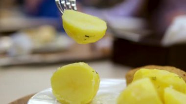 Lezzetli bir şekilde pişirilmiş altın patatesler. Yemek için çatal kullanılıyor. Yüksek kalite 4k görüntü