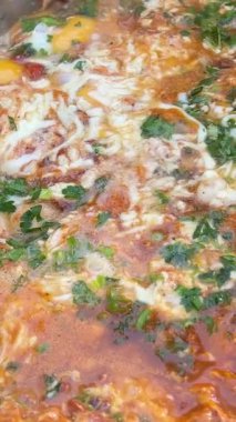 Domates sosunda kızartılmış Shakshuka tabağı, acı biber ve soğan. Matboukha adlı başka bir yemek üzerine hazırlanabilir..