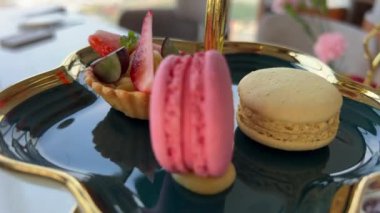 Makarna aperatifi ve tatlı olarak da tatlı olarak makarnanın ortasında ve yanında bardaklar, fincanlar, kahve molaları ve hamur işleri var. Yüksek kalite 4k görüntü