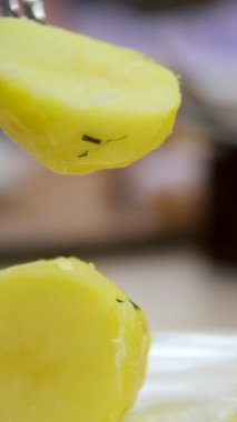 Lezzetli bir şekilde pişirilmiş altın patatesler. Yemek için çatal kullanılıyor. Yüksek kalite 4k görüntü
