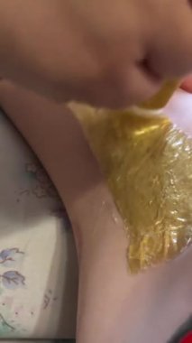 Kadın kılları alınır, koltuk altı kılları alınır. Usta koltukaltlarına ahşap bir sopayla sıcak balmumu sürüyor ve soğuk ve yapışkan balmumunu çabucak çıkarıyor. Yüksek kalite 4k görüntü