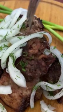 Bir adamın ellerinin bir parça ızgara eti kremalı sosa batırdığı yakın plan bir fotoğraf. Lokantada lezzetli et yemekleri yeme fikri. Yüksek kalite 4k görüntü