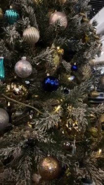 Altın ayna ve mat toplar. Yılbaşı ve bulanık alışveriş merkezinin arka planında Noel ağacı süslemeleri var. Yüksek kalite 4k görüntü