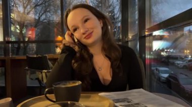 Geceleri kafede akıllı telefon kullanan genç bir kadın. Yüksek kalite 4k görüntü