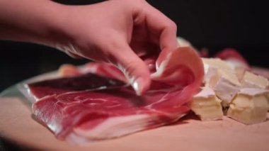 Lezzetli bir jambon ve peynir hazırlıyorum. Sofra gurmesi partisinde paylaşacak meyveli jambon ve peynirli leziz bir yönetim kurulu. Yüksek kalite 8K görüntü