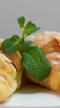 Çıtır çıtır ve tereyağlı kruvasan beyaz bir tabakta yavaşça döner. Yakın plan bir Fransız pastasının sinematik çekimi. - Evet. Yüksek kalite 