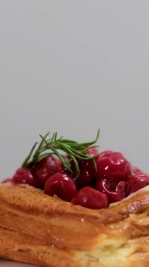 Beyaz tabak sergisinde vişneli turta ve hamur işi.