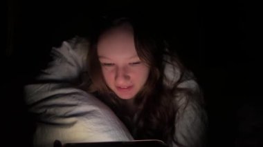 Genç Çekici Bir Kadının Gece Yatağında Akıllı Telefondan Oyun Oynayan Portresi. Yüksek kaliteli 4K televizyon dizisi 