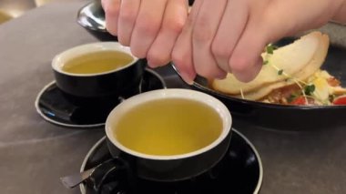 İki fincan çay, arka planda siyah şekerli Sezar salatası ekle. Yüksek kalite 4k görüntü