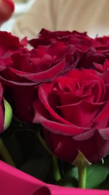 Profesyonel kadın çiçekçi, çiçek hazırlayan çiçekçi atölyede çiçek buketi için kırmızı güller, çiçekçi. Çiçekçilik, el yapımı ve küçük işletme konsepti. Yüksek kalite 4k görüntü