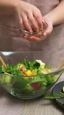 Kesilmiş kadın vejetaryen salatasına ceviz ekliyor deniz yosunu ve dilimlenmiş avokado ile, bitki temelli diyet. Yüksek kalite 8K görüntü