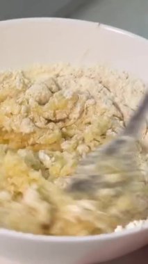 4K 'de şeffaf bir cam kasede çikolatalı kurabiye yapıp karıştırıyorum. Çikolata parçacıklı kurabiyeleri adım adım hazırlama kavramı. Koyu çikolata parçacıklı kurabiye hamuru yapma işlemi