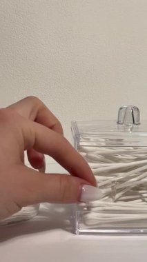 Beyaz kulaklıklar ve pamuk pedler beyaz arka planda dururlar. Hijyen, yatak odası, banyo, güzellik, kişisel bakım, temizlik, ev. Yüksek kalite 4k görüntü