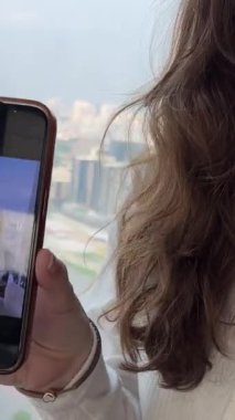 Kadın havaalanında cep telefonu kullanıyor, internette uçuş sörfünü bekliyor. Yüksek kalite 4k görüntü