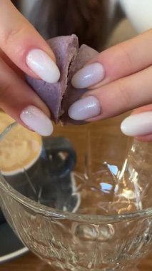 Beyaz seramik tabakta yaban mersinli çatallı mor makarna kurabiyesi. Gri beton arka plan ve turuncu tekstil. Yan görüş. mor yuvarlak fındık keki