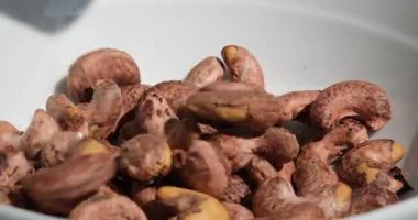 Pikabın üstünde kaju parçaları var. Bitki bazlı malzeme. Kurutulmuş fındık. Makro atış. Çiğ çerez. Kabuksuz kaju fıstığı istifleyin. Döndürün, kapatın. Fındık taneleri. kaju fıstığı.