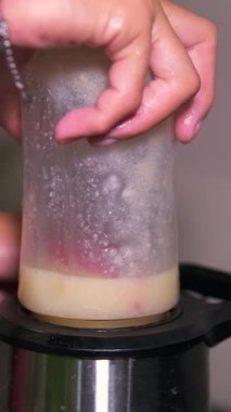 Birisinin bulanık video arkaplanı ahşap havan ile kırmızı biber sosunu karıştırıyor, chili sosunu çok taze ve taze yapmak için kırmızı bibere bakıyor.. 