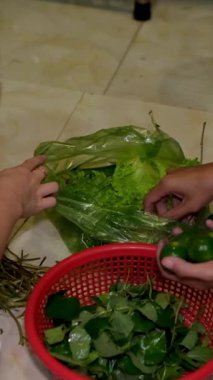 Yerde yatan Asyalı kadınlar, biber sebzeleri satan bir dükkandan alınmış sebzeleri sıralıyorlar. Yüksek kaliteli FullHD görüntüler