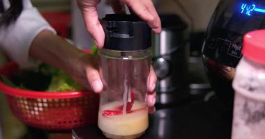 Birisinin bulanık video arkaplanı ahşap havan ile kırmızı biber sosunu karıştırıyor, chili sosunu çok taze ve taze yapmak için kırmızı bibere bakıyor.. 