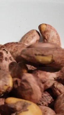 Pikabın üstünde kaju parçaları var. Bitki bazlı malzeme. Kurutulmuş fındık. Makro atış. Çiğ çerez. Kabuksuz kaju fıstığı istifleyin. Döndürün, kapatın. Fındık taneleri. kaju fıstığı.