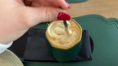 Masadaki kafede oturan, haber okuyan, röportaj yapan, yeşil ekranlı online giyimli bir kadın. Karışık kahve, kapuçino ya da latte. Yüksek kalite 4k görüntü