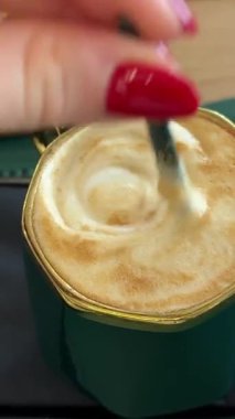 Masadaki kafede oturan, haber okuyan, röportaj yapan, yeşil ekranlı online giyimli bir kadın. Karışık kahve, kapuçino ya da latte. Yüksek kalite 4k görüntü