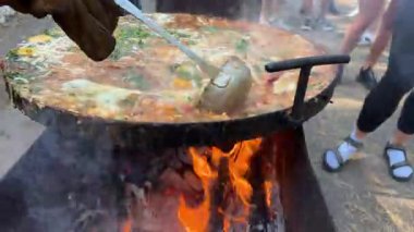 Açık havada pişirme sahnesinde yumurta kızart. Parlak güneş ışığı altında kırsal bir fırında haşlanan bir tencere güveç ile. Yüksek kalite 4k görüntü