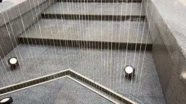 Çeşme teli hareketli su duvarı iç ofis binasının cam evindeki şelalenin iç tasarımı. Yapay şelale fıskiyeleri tavandan veya iç kısımdaki dekoratif fıskiyelerden aşağı akar