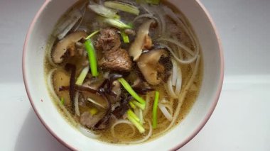 Vietnam mantarlı pirinç şehriyeli şehriyeli şehriye çorbası Shaitake mantarı odunsu siyah mantar bir kase kişniş çorbası. Yüksek kalite 4k görüntü