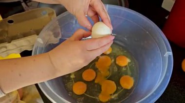 Yumurtaların miksere kırılıp, besleyici bir karışıma hazırlandığı yakın plan. Bir sürü sarısı beyaz kadın elleri cam kasede yumurta çırpıyor.