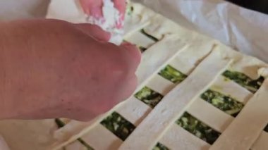 Ev sahibesi turta için dolguları karıştırıyor. Peynirli turta yapmak için peynirli ıspanak. Ispanaklı turta pişirme işlemini adım adım yoğur