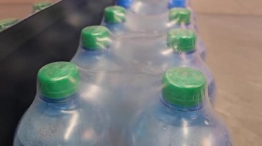 Dükkandaki plastik şişeden su seçen kadın ellerine yakın çekim. Çeviriyorum. Yüksek kalite 4k görüntü