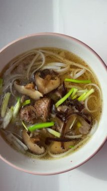 Vietnam mantarlı pirinç şehriyeli şehriyeli şehriye çorbası Shaitake mantarı odunsu siyah mantar bir kase kişniş çorbası. Yüksek kalite 4k görüntü
