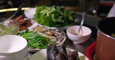 Masada Asya mutfağı bir sürü sebze ve yeşillik bir kadın evde bir tabak yemeğe haşlanmış pirinç döker Vietnam 'da gerçek hayat