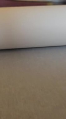 Bir rulo kağıt hazırla. Kadın elleri masaya bir rulo kağıt itiyor.