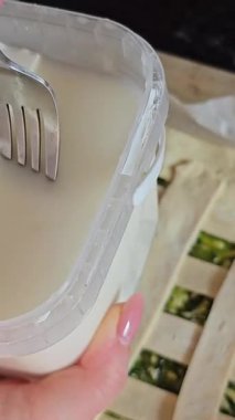 Ev sahibesi turta için dolguları karıştırıyor. Peynirli turta yapmak için peynirli ıspanak. Ispanaklı turta pişirme işlemini adım adım yoğur