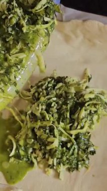 Ev sahibesi turta için dolguları karıştırıyor. Peynirli turta yapmak için peynirli ıspanak. Ispanaklı turta pişirme işlemini adım adım yoğur