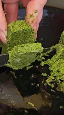 Donmuş pesto soslu kadın elleri bıçak parçalarıyla kesilmiş lezzetli makarna sosu. Yüksek kalite 4k görüntü