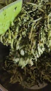 Ev sahibesi turta için dolguları karıştırıyor. Peynirli turta yapmak için peynirli ıspanak. Ispanaklı turta pişirme işlemini adım adım yoğur