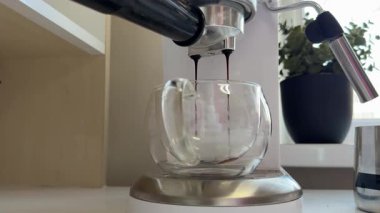 Kahve makinesi bardağı dolduruyor. Kahve makinesiyle kahve yapıp fincana koymak, otomatik kahve makinesinden çıkan espresso kahvesi. Kahvaltıda içecek.