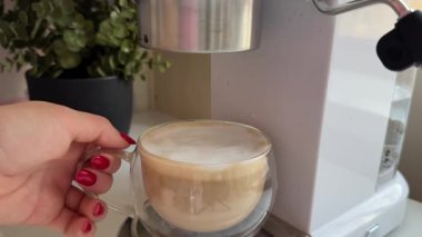 Barista kahve makinesinde kahve hazırlıyor, kadın eli kahve fincanını tutuyor. Yüksek kalite 4k görüntü