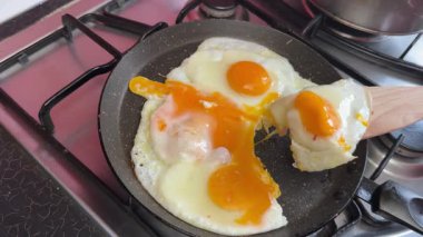 Güneşli tarafı ters çevirme girişimi başarısız oldu. Kızartma tavasından spatulayla bir yumurta al.